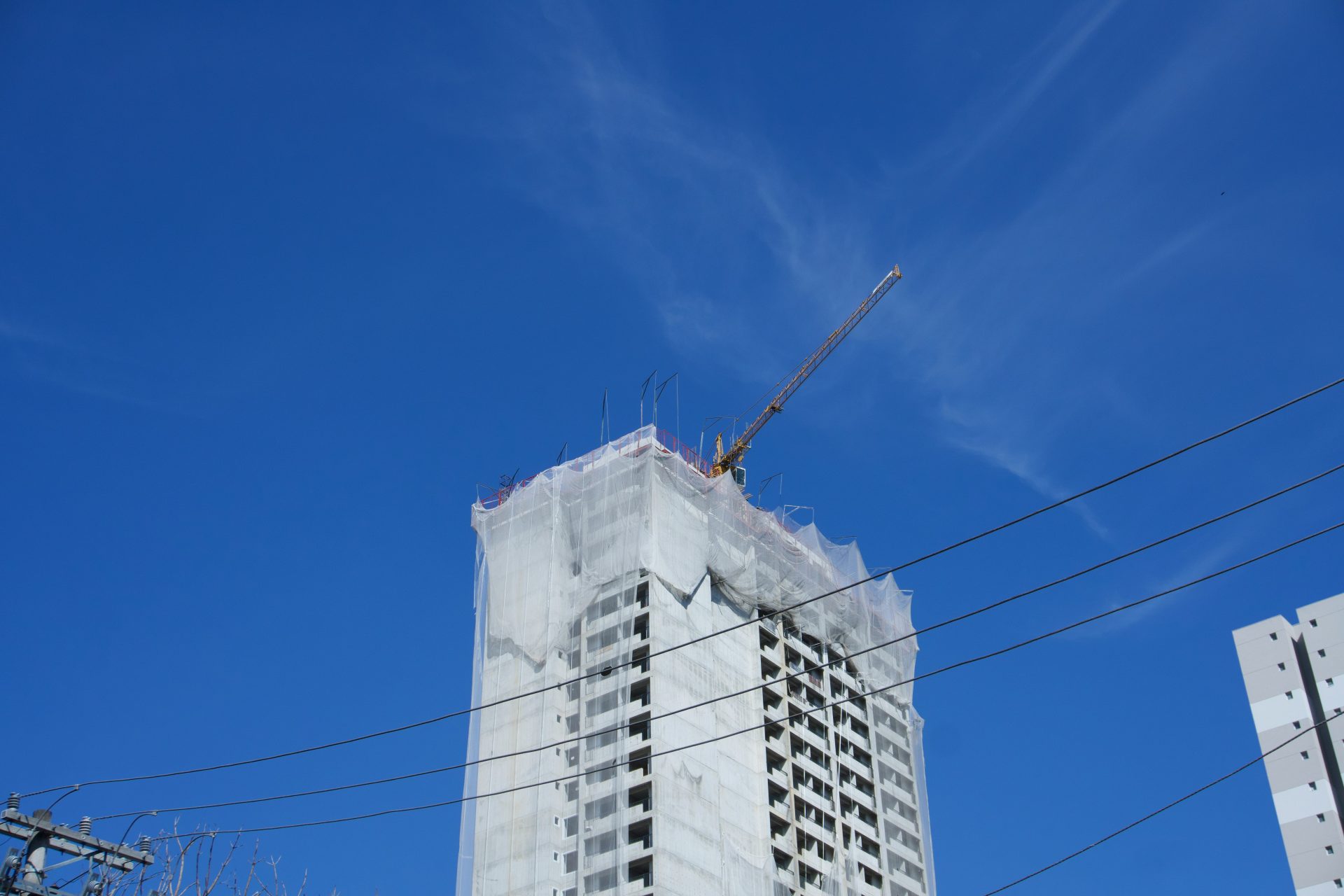 Immeuble de grande hauteur en construction avec une grue sur fond de ciel bleu